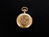 a gold pocket watch on a black background with a black background