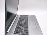 a silver laptop with a black keyboard on a white surface