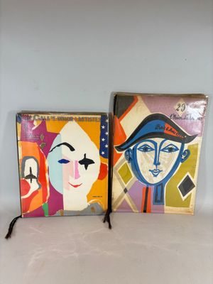 Deux tableaux représentant des visages sont exposés côte à côte sur une étagère.
