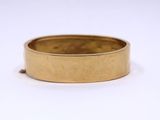 a close up of a gold ring on a white surface