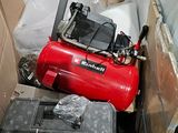 a red air compressor sitting inside of a cardboard box