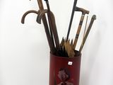 un vase rouge contenant un bouquet de vieilles cannes