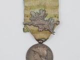 une vieille médaille ornée d'un ruban doré sur fond blanc