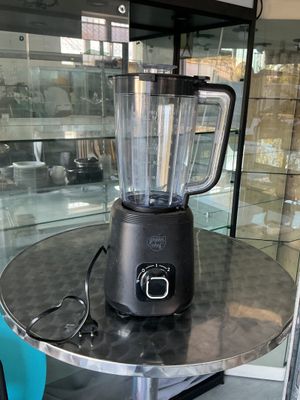 un mixeur posé sur une table devant une vitrine