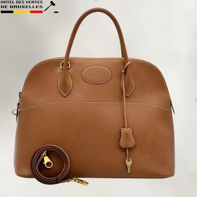 un gros plan d'un sac à main avec une clé sur fond blanc
