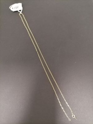 a silver necklace with a cat on it sitting on top of a table