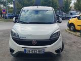 La voiture blanche est garée sur le parking, à côté de la voiture jaune.