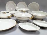 a lot of white and gold plates and bowls on the table