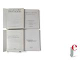 three open books sitting on top of each other on a white surface