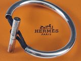 un bracelet en argent muni d'un fermoir en métal sur une surface en cuir