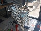 une chaise et un extincteur posés devant une porte vitrée
