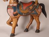 a wooden horse with a saddle on it ' s back