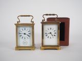 two small clocks sitting next to each other on a table