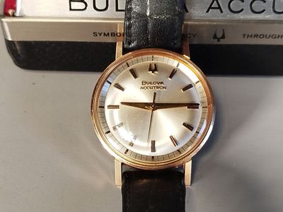 a watch sitting on top of a book on a table