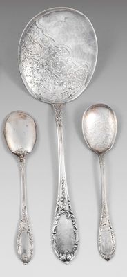 trois cuillères en argent et deux cuillères en argent sur une table