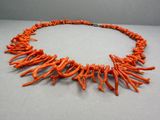 un collier orange orné d'une grappe de coraux