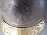 a close up of a silver vase on a table