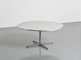 une image représentant une table blanche posée sur un sol en béton