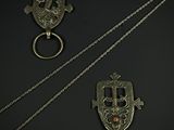 three pieces of silver jewelry on a black surface