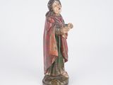 an old statue of a woman in a red robe holding a book