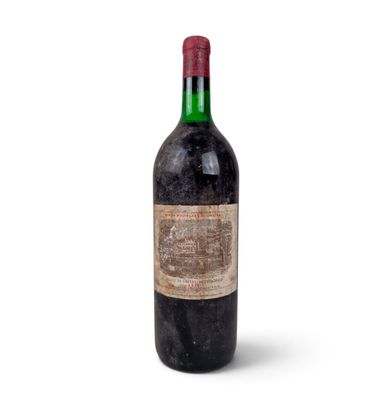 une vieille bouteille de vin posée sur une surface blanche