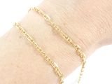 a close up of a person ' s arm wearing a gold chain bracelet