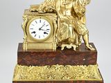 a gold clock sitting on top of a marble table