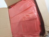 a cardboard box with a bunch of pink sheets inside of it