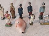 de nombreuses figurines représentant des personnes et un cochon, posées par terre