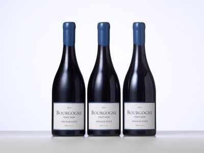 trois bouteilles de vin rouge posées sur une table