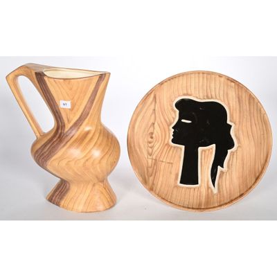 un vase en bois et une assiette en bois sur laquelle est représentée une femme