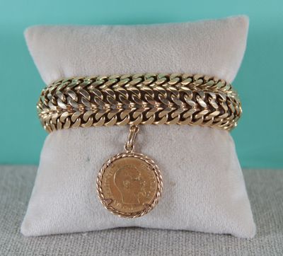 a gold chain bracelet with a coin charm on it