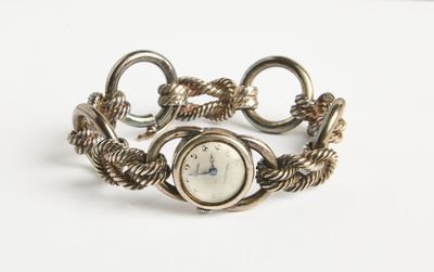 une image d'un gros plan d'une montre-bracelet sur une surface blanche