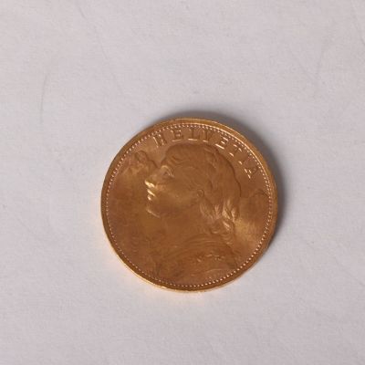 a small coin on a white surface with a white background