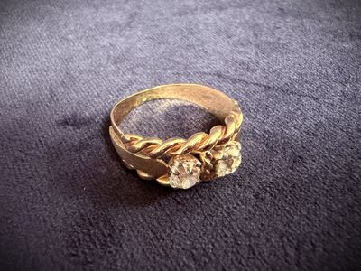 a close up of a gold ring on a black surface