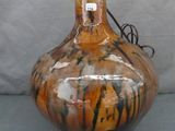 un vase posé sur une table avec une lampe dessus