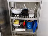 a metal shelf with pots and pans on it in a kitchen