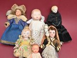 five dolls that are sitting together on a red surface