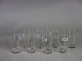 six empty glasses are lined up on a white surface