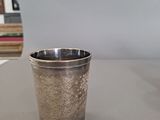 a silver cup sitting on a table next to a stack of books