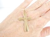 a person ' s hand with a gold cross on it