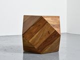 a wooden block on the floor in a white room