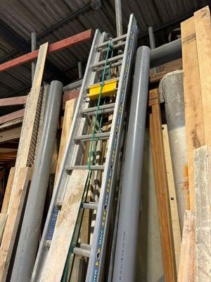 une échelle appuyée contre un tas de bois