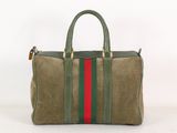 le sac rayé vert et rouge est posé sur une surface blanche