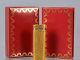 a red and gold box with a gold lighter in it