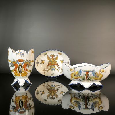 trois pièces de porcelaine sont posées sur une surface noire