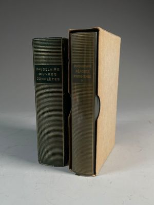 un vieux livre posé sur une boîte en carton, à côté d'un livre plus petit