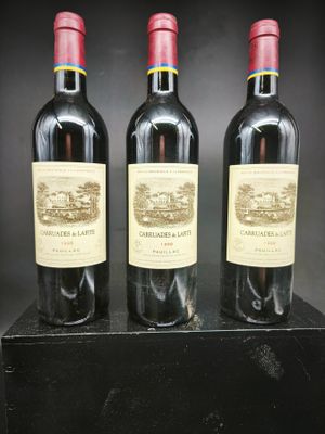 trois bouteilles de vin sont posées sur une boîte noire