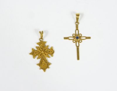 deux croix en or et un pendentif en forme de croix sur fond blanc