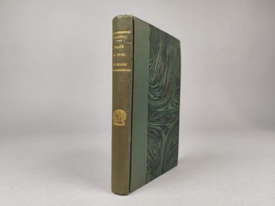 un vieux livre à la couverture verte posé sur une surface blanche